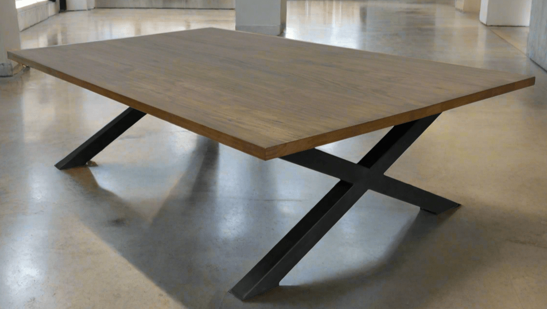 An expansive solid wood dining table seating ten or more, featuring a lengthy rectangular top and a double pedestal base, displayed in a spacious dining hall ready for a large gathering.