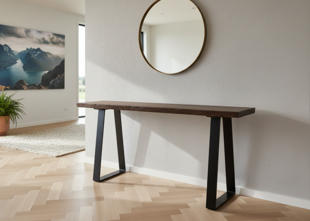 Wooden console table with black metal legs in a room with a round mirror on the wall.