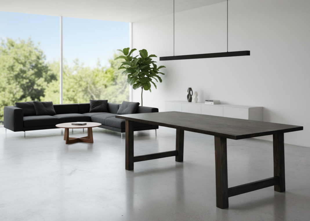 A sleek farmhouse-style dining table crafted from solid wood, featuring straight modern legs and a spacious rectangular top, shown in a bright kitchen dining area with rustic décor accents.