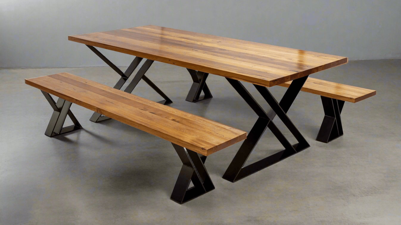 A modern dining table featuring distinctive Z-shaped metal-and-wood legs supporting a long wooden table top, creating a bold geometric profile in a stylish dining room.