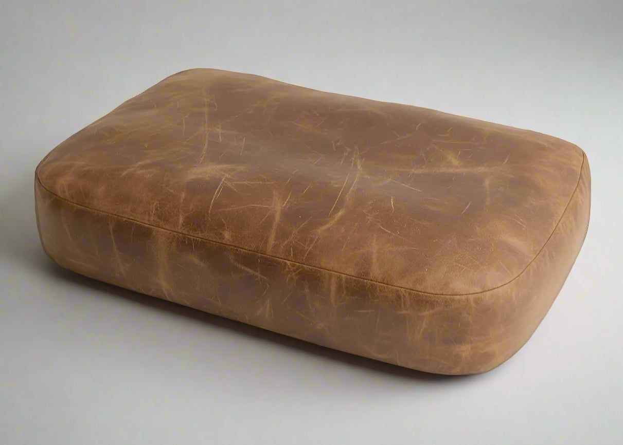Brown leather ottoman on a white background