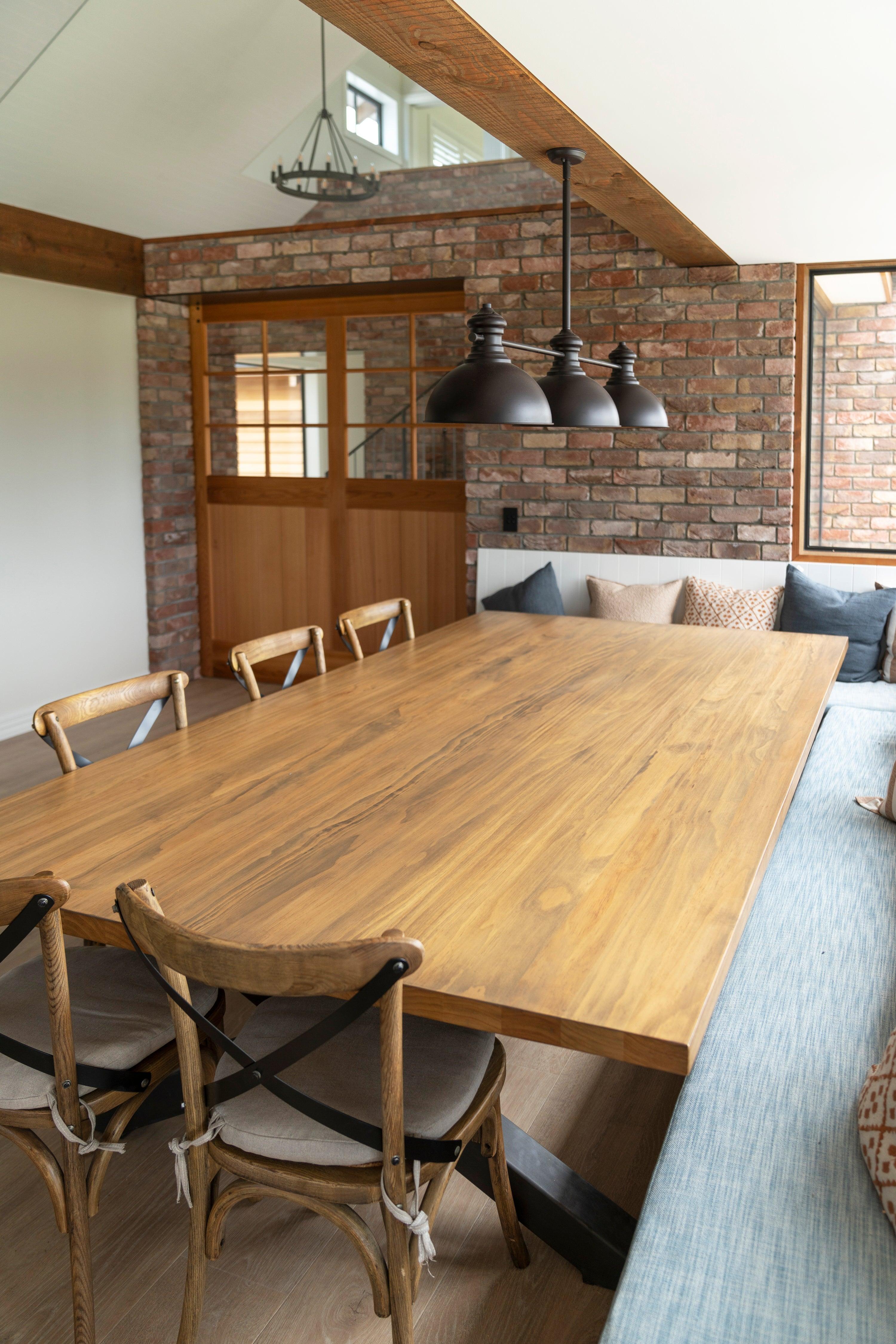 Large custom timber dining table in a lodge-style interior