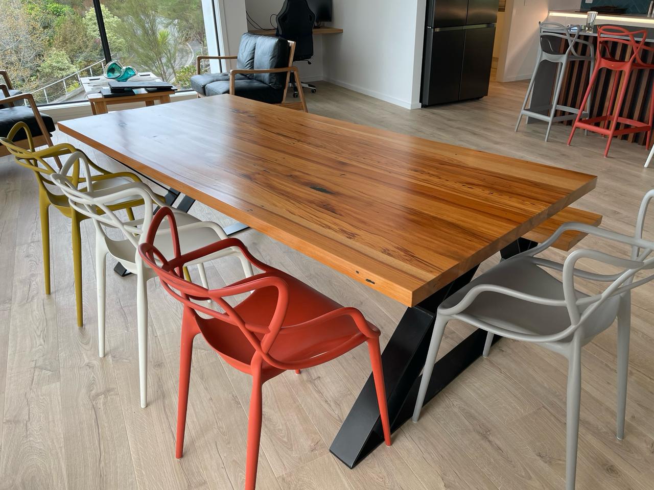 Rimu dining table with a black steel base in a modern open-plan home