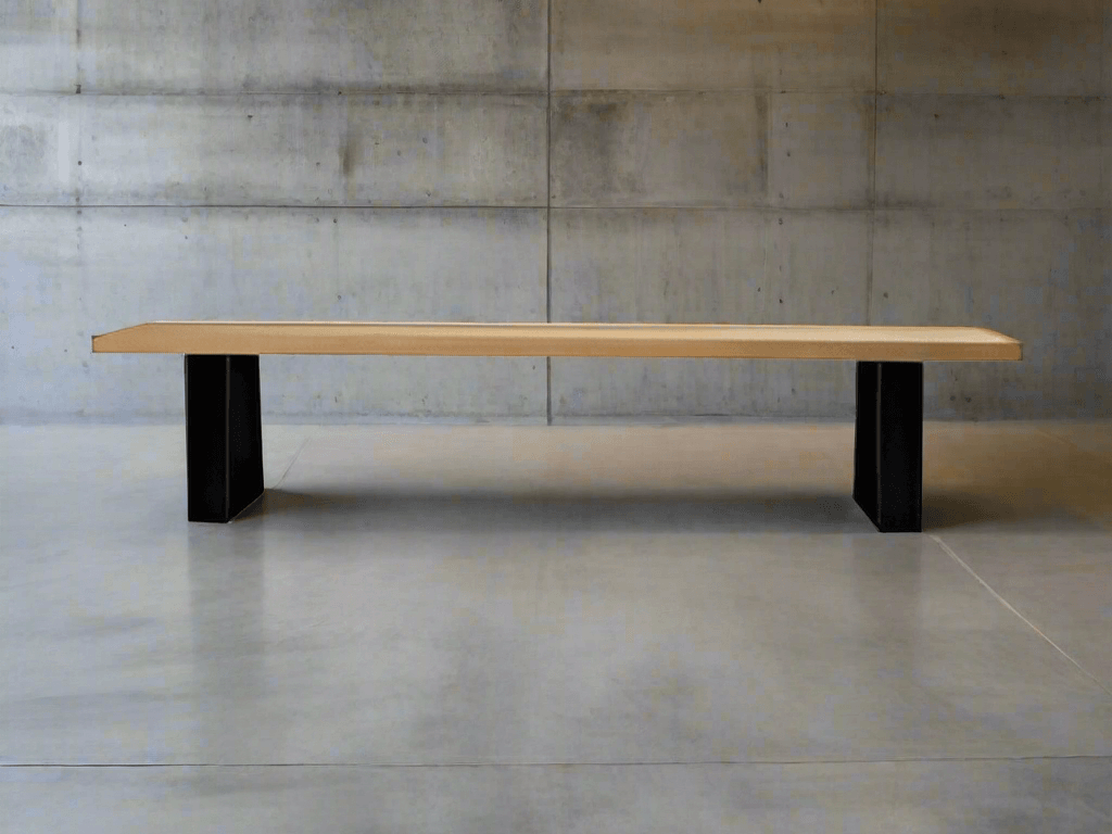 Light rectangular bench with black block legs against a grey wall