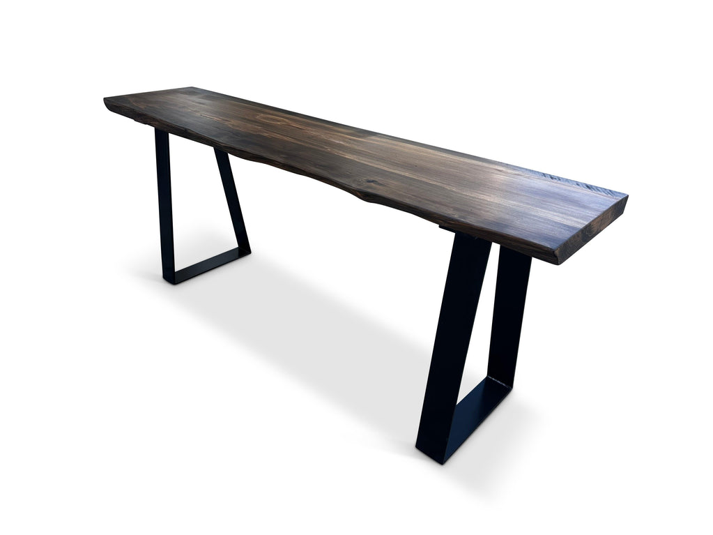 Long narrow console table with dark irregular-edge top and black trapezoid legs