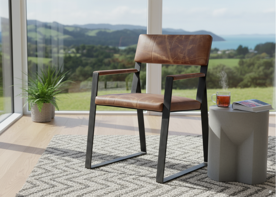 Chair with brown seat and backrest, black frame and armrests by large windows