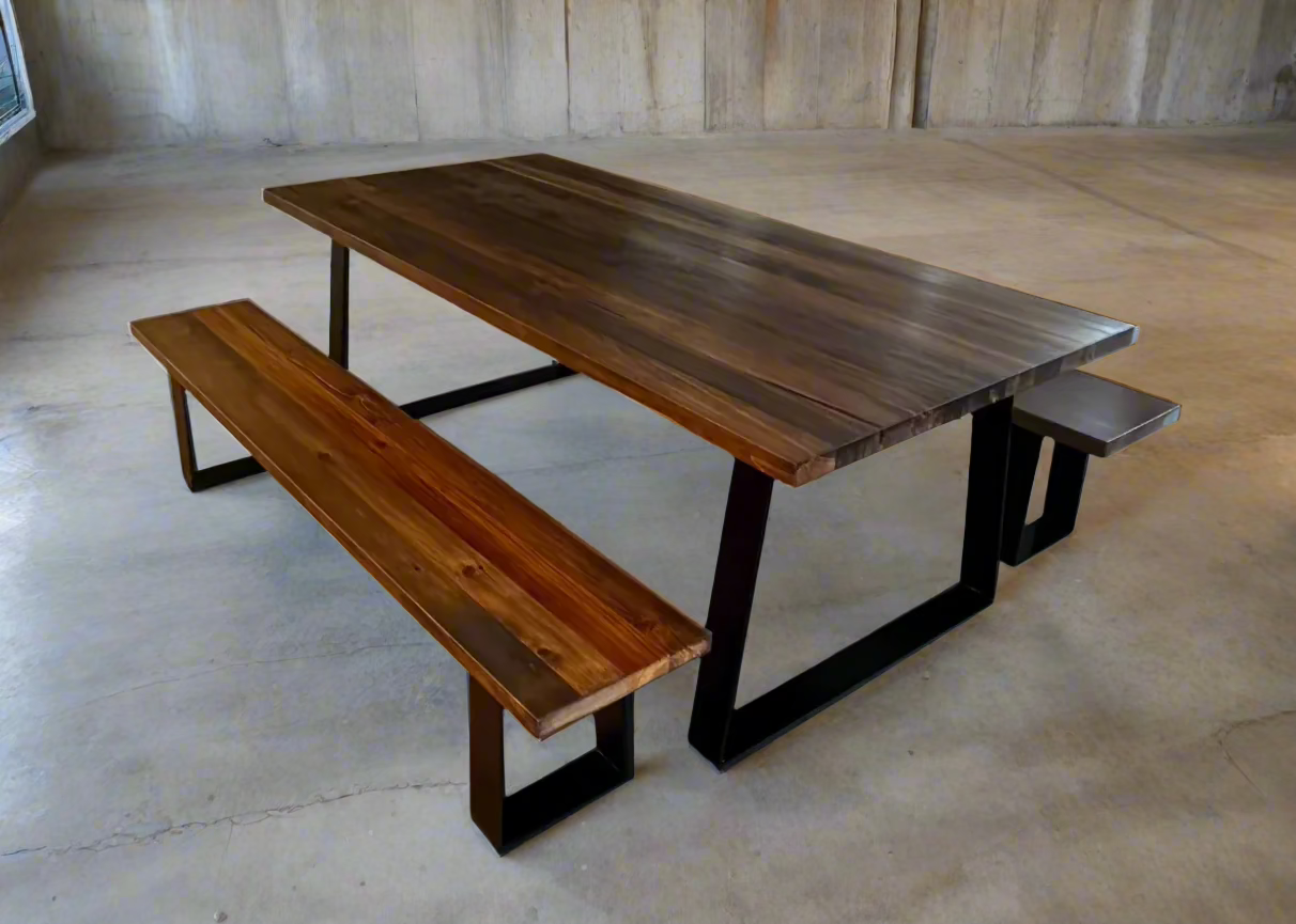 A handcrafted solid wood dining table with black powder-coated steel angled legs, shown with a matching wood bench in a contemporary dining room.