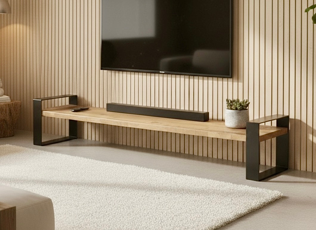 Entertainment unit below a wall-mounted TV on a slat wall