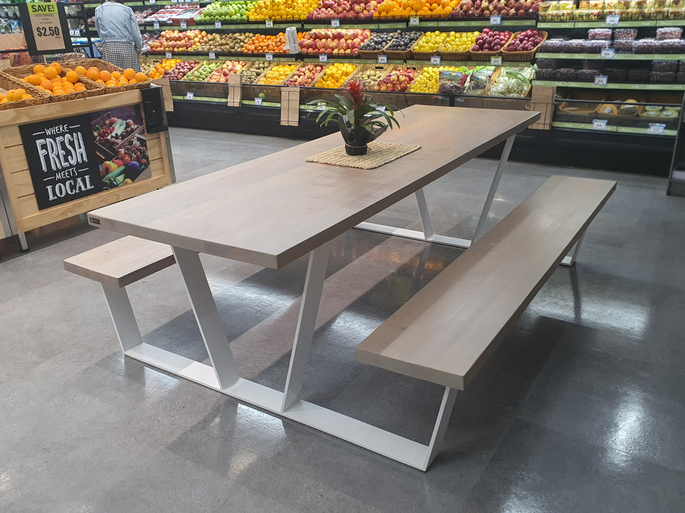 Picnic-style table with benches in a grocery produce area