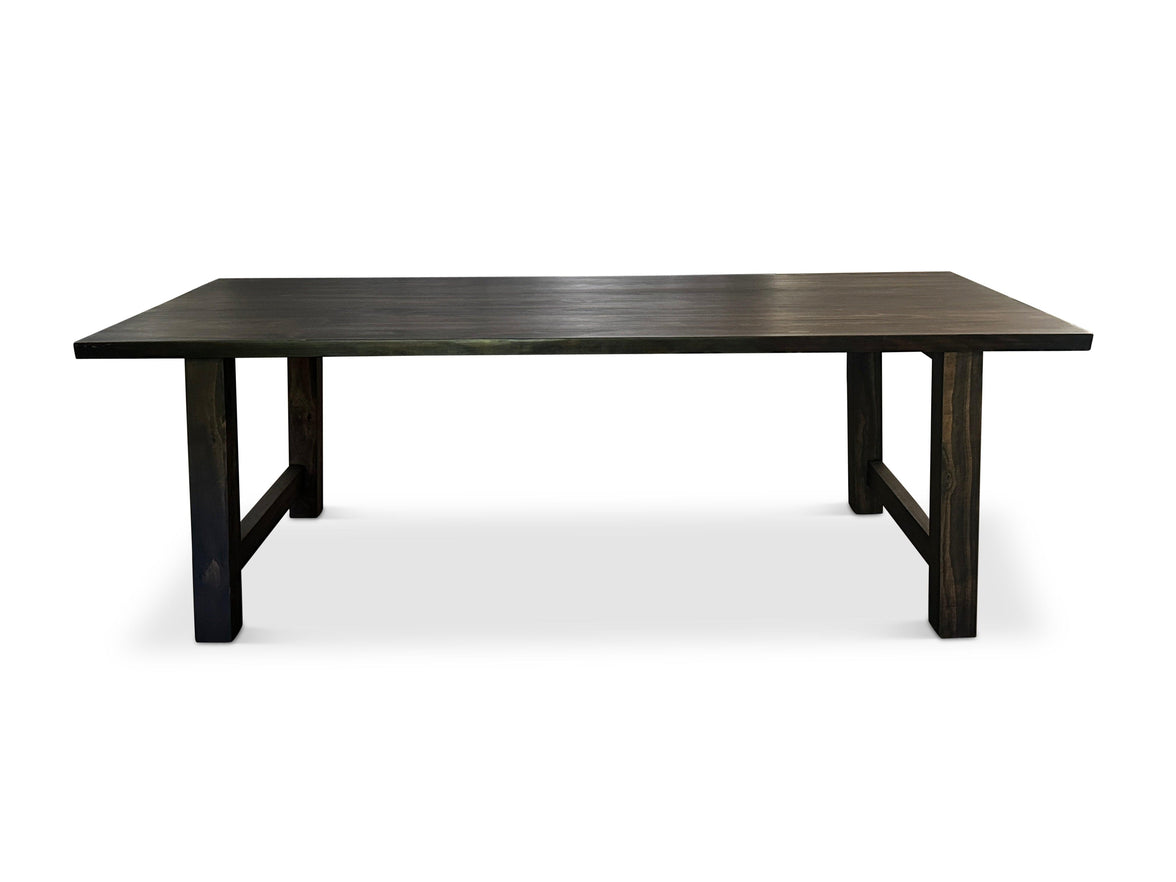 Modern Homestead dining table in dark-stained solid timber with trestle-style all-timber legs, studio shot
