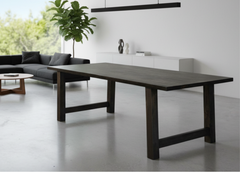 A sleek farmhouse-style dining table crafted from solid wood, featuring straight modern legs and a spacious rectangular top, shown in a bright kitchen dining area with rustic décor accents.