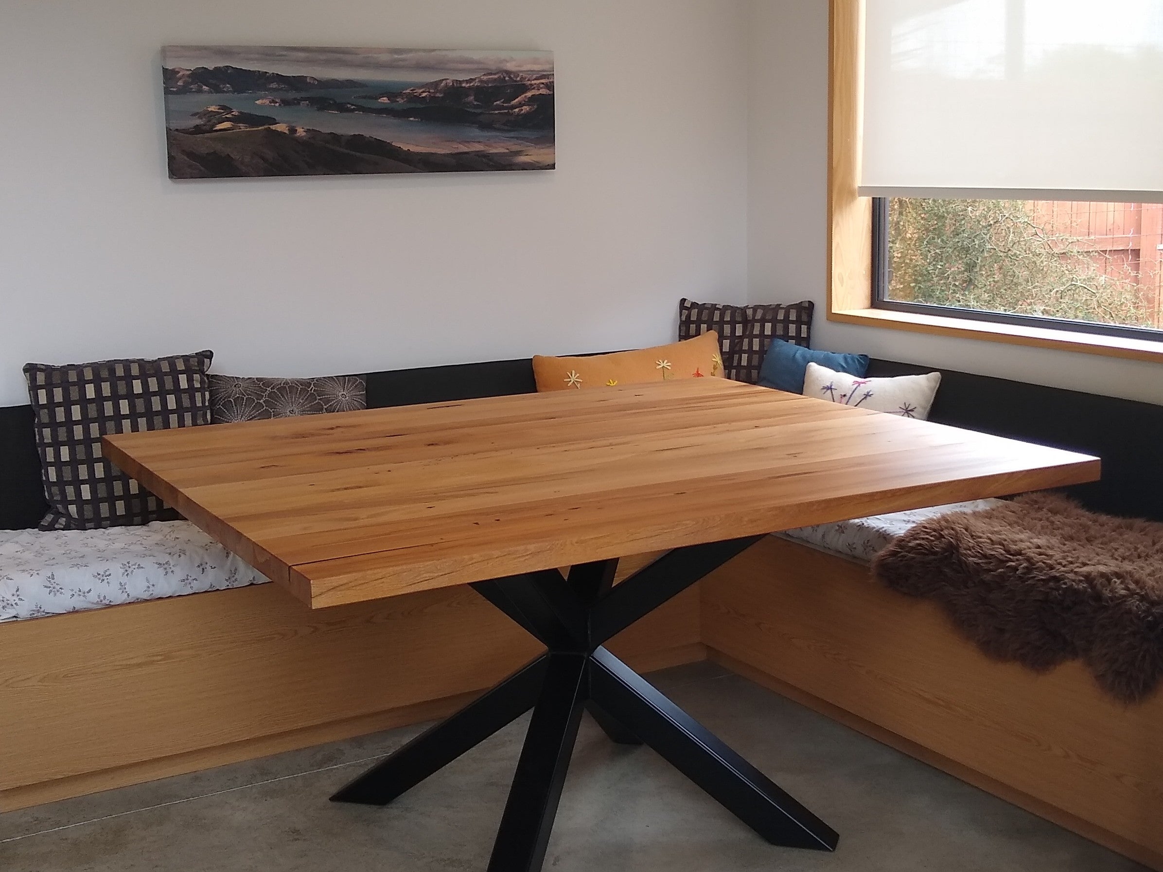 Rimu Steel Asterix dining table in a warm dining booth setting
