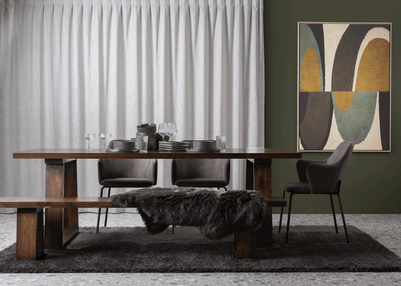 A solid wood dining table featuring uniquely angled wooden legs and a matching bench, showcasing natural timber grain in an airy modern dining space.