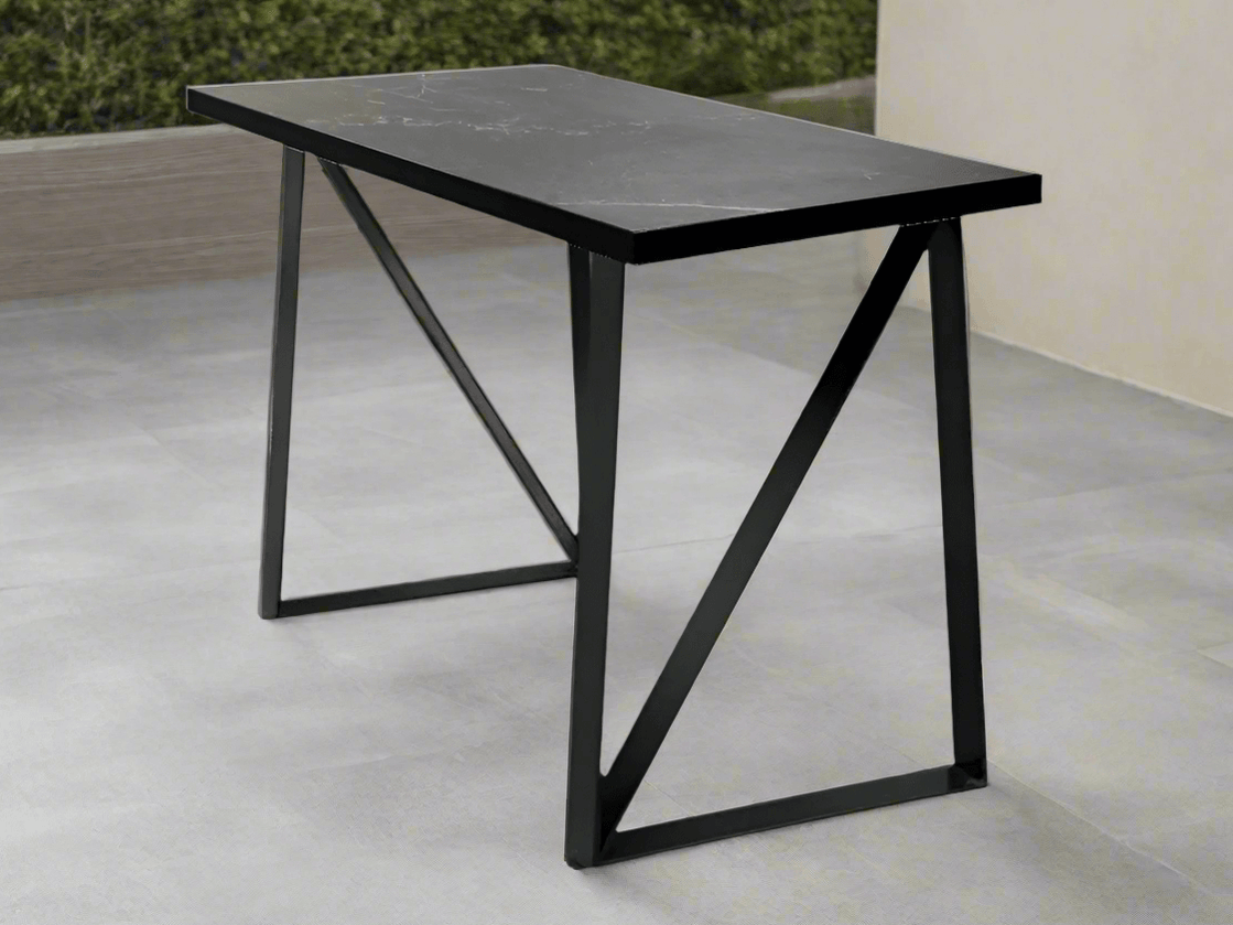 Black rectangular bar leaner with grey-veined top on a tiled patio