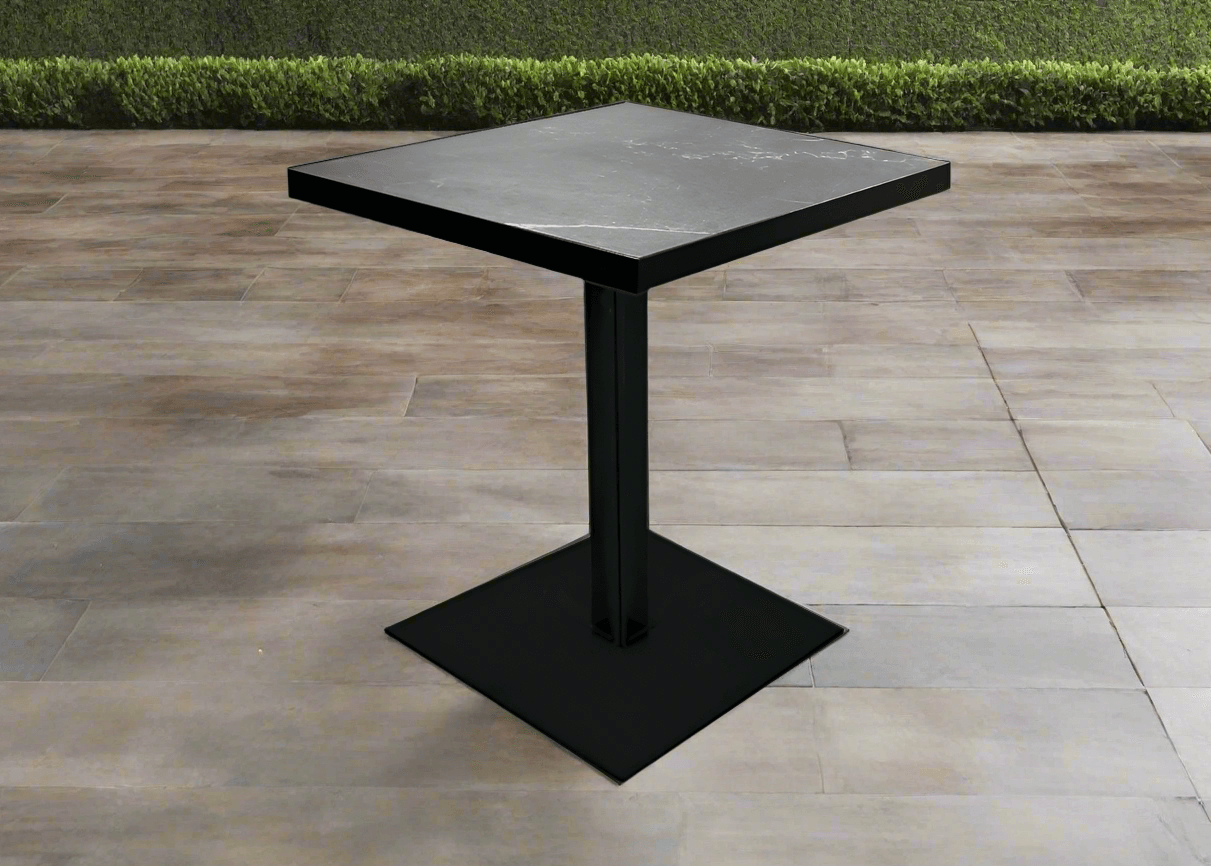 Black square pedestal café table on an outdoor patio