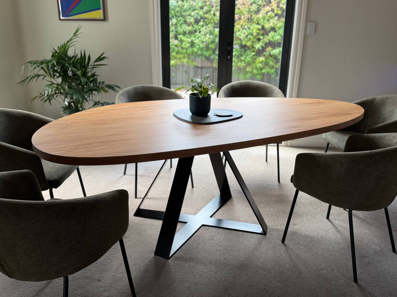 Pebble Crossroads dining table with rounded timber top and black Crossroads base in a dining room