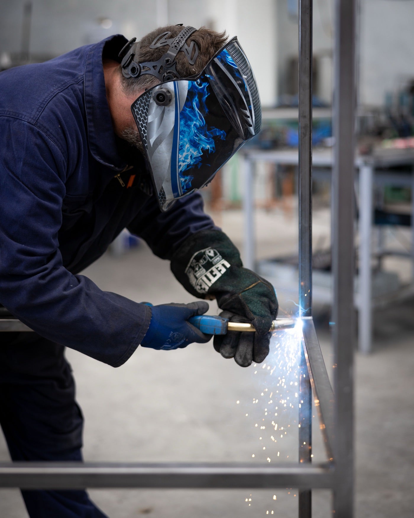 A steel table frame being welded.